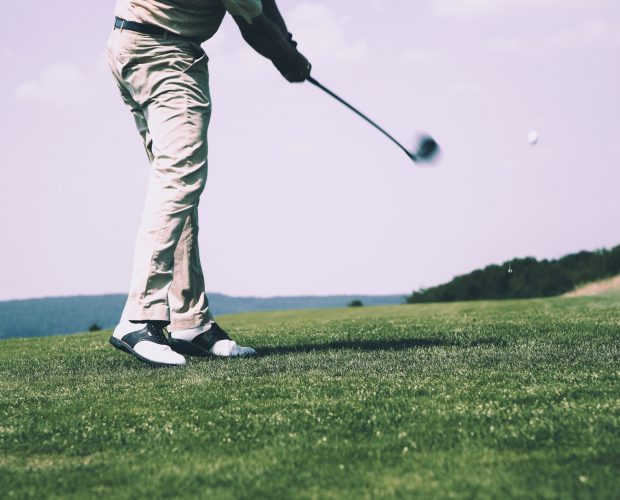 Golfer with stylish outfit on golf course